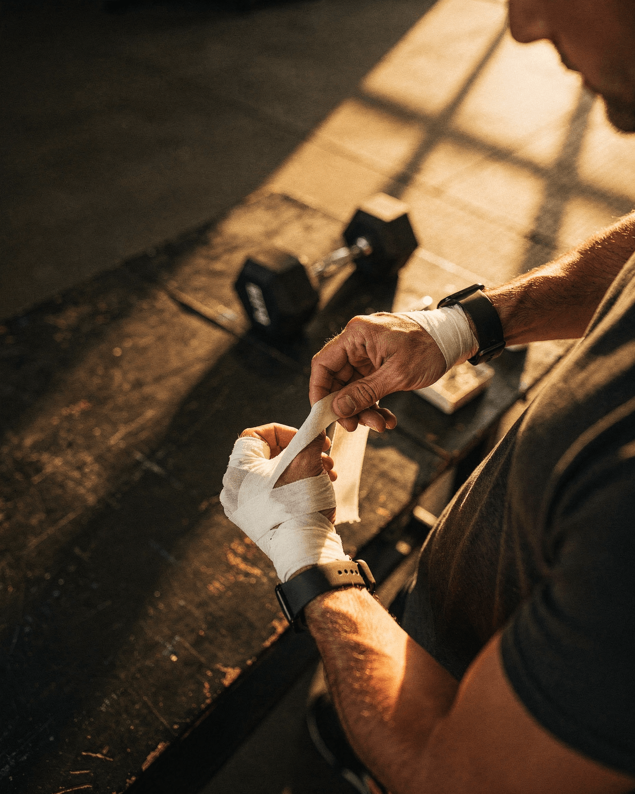 Hands wrapping athletic tape, focused light