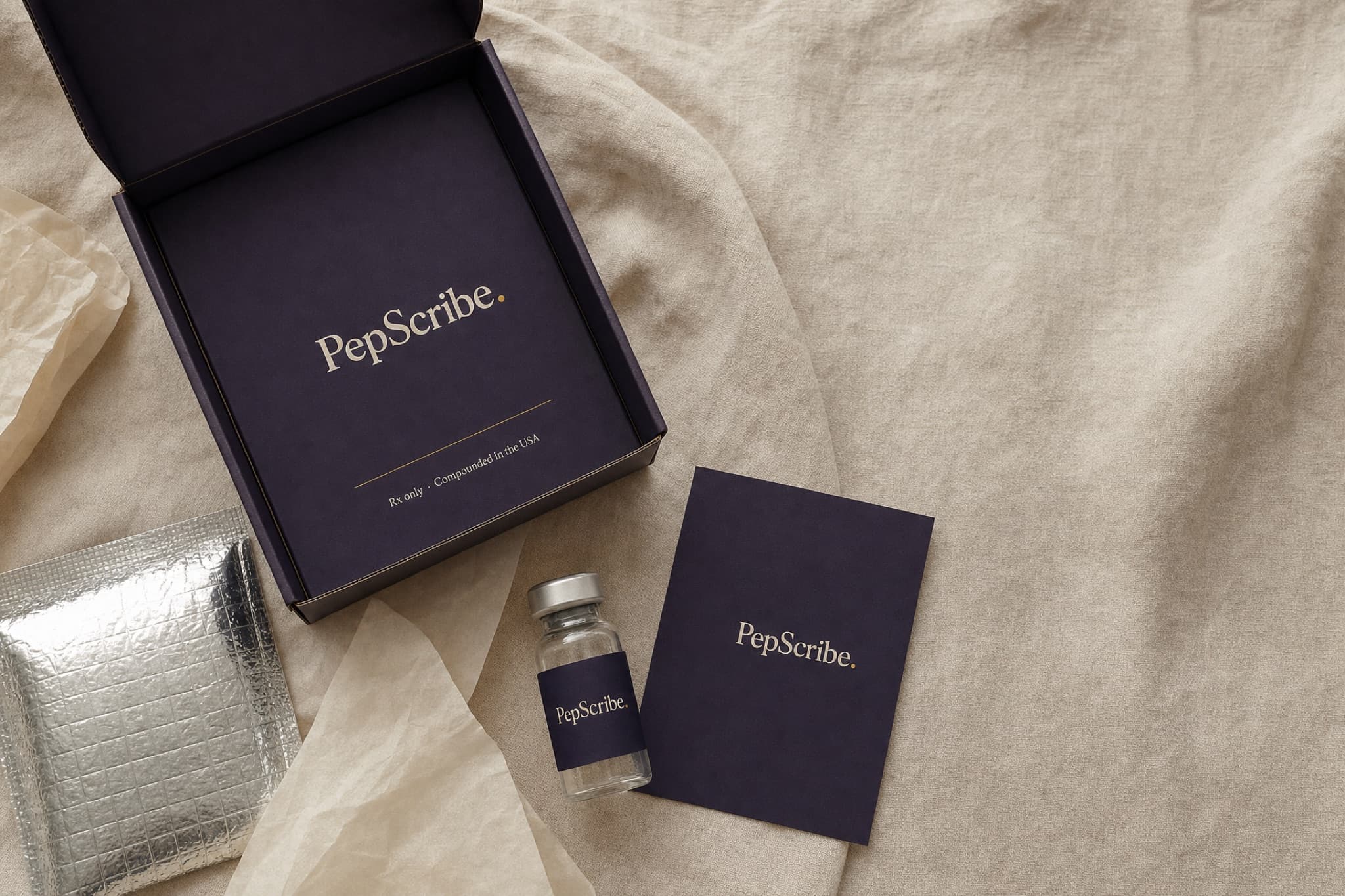 An opened PepScribe shipping kit laid out on cream linen: the box, tissue paper, a foil cold pack, a vial, and a card