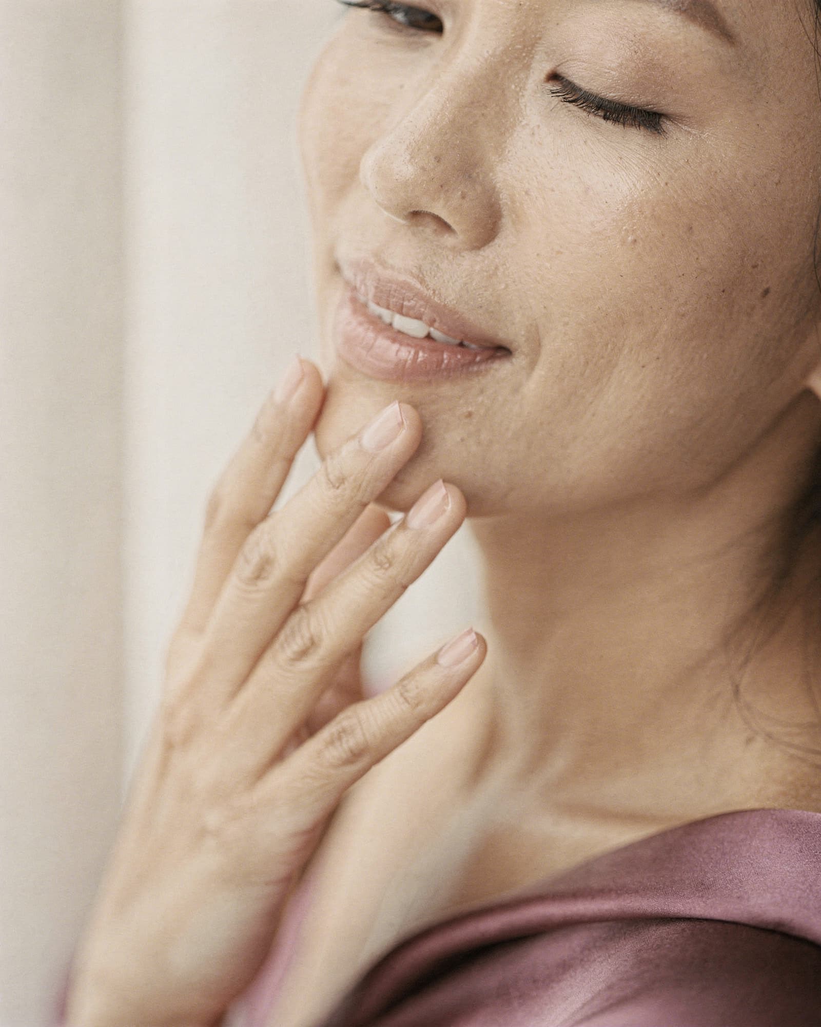 A woman outdoors on an overcast day, fresh-faced with natural skin