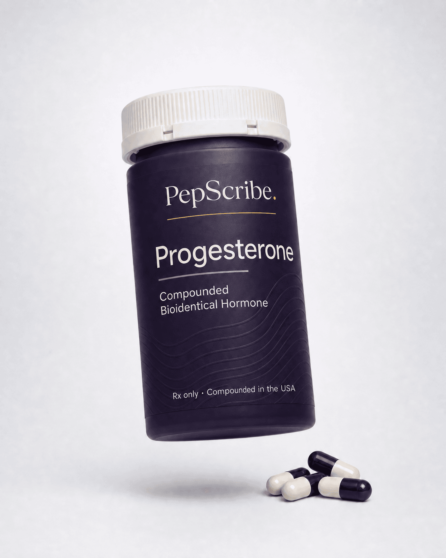 A PepScribe-branded compounded bioidentical progesterone capsule bottle, angled against a soft studio backdrop.