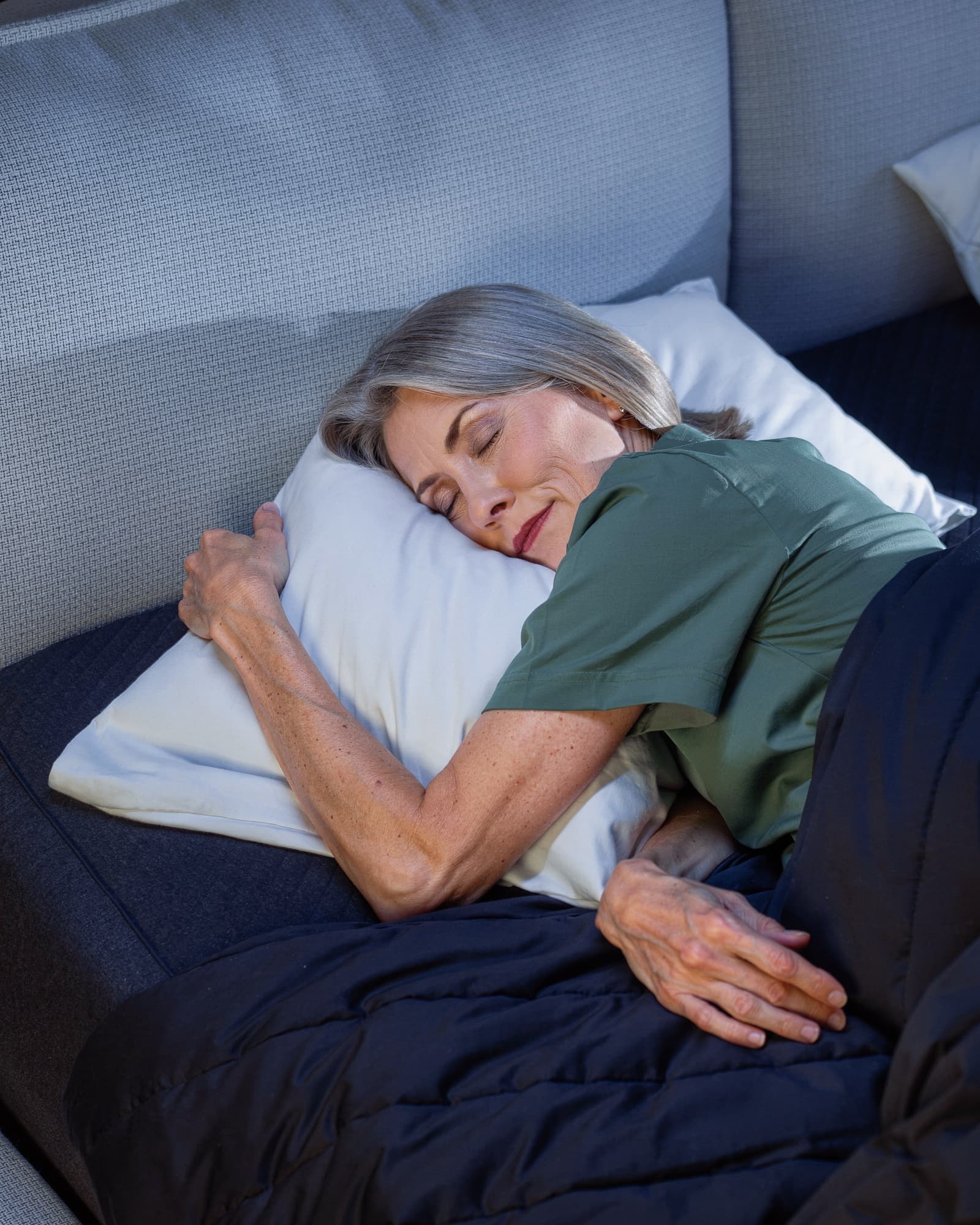 An American woman in her early fifties sleeping peacefully on her side, serene and restful.